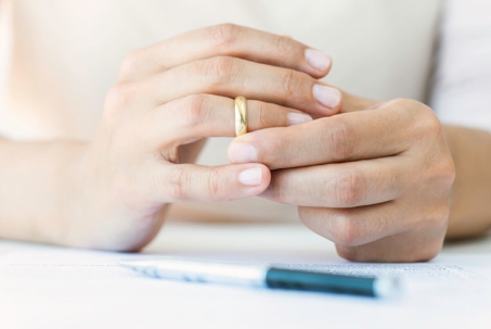 Hands of caucasian female who is about to taking off her wedding ring